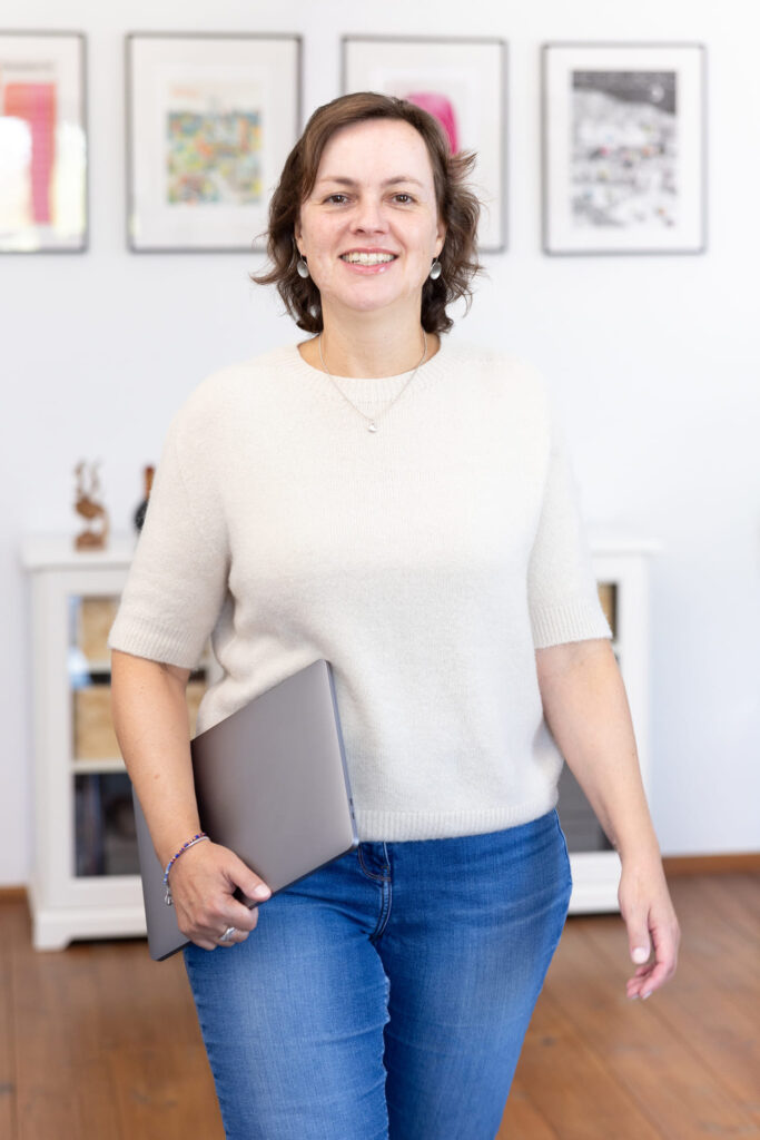 Friederike Ruffmann Oliveira unterwegs mit Laptop unterm Arm