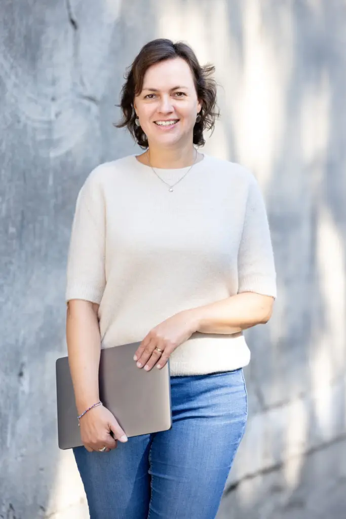 Friederike Ruffmann Oliveira steht hier mit Laptop, sie ist eine Online Assistenz